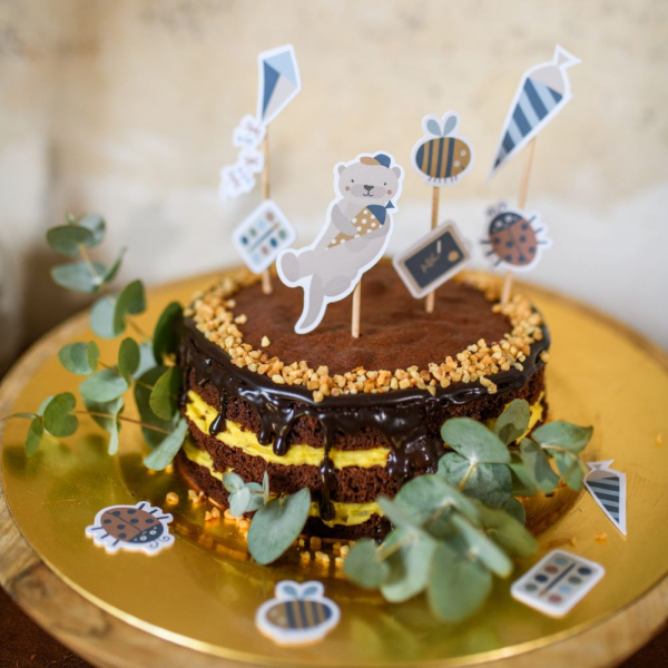 Schulkind Cake Topper 'Nature Kids' von Ava & Yves auf einem Einschulungskuchen in natürlichen Farbtönen.